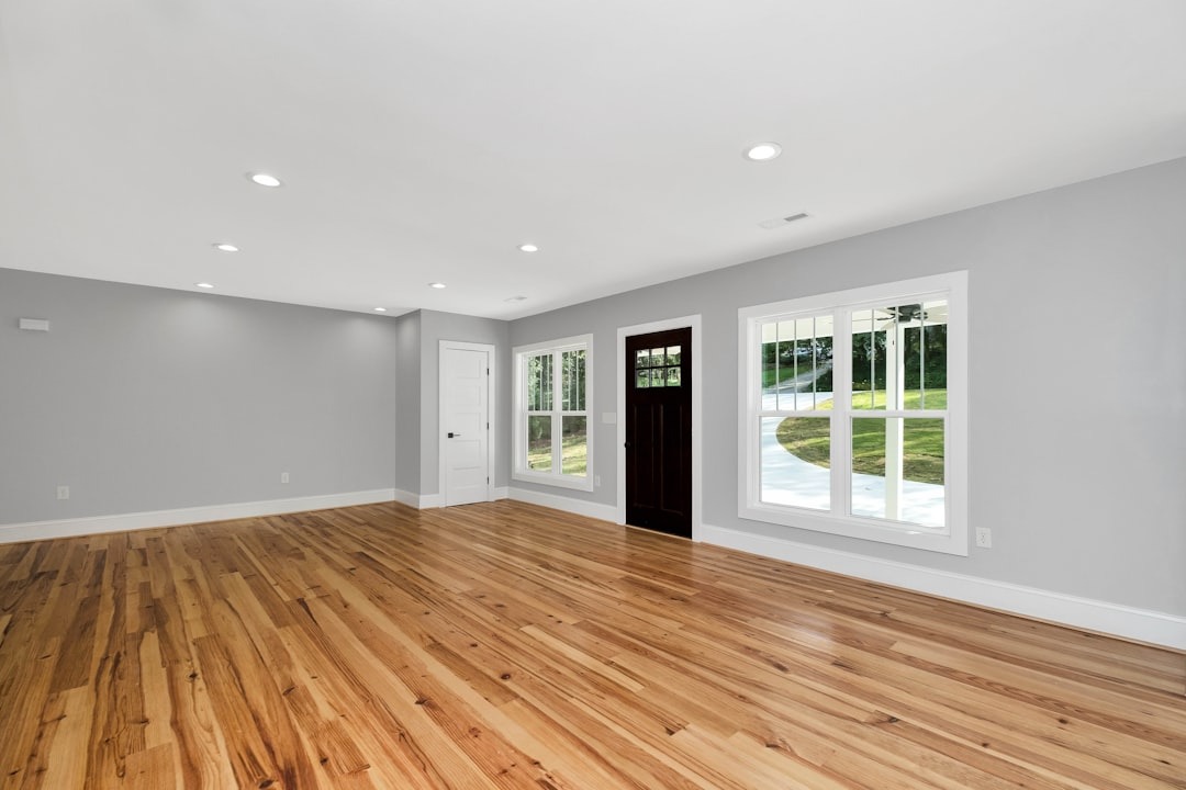 Newly finished room with hardwood floors and grey walls.